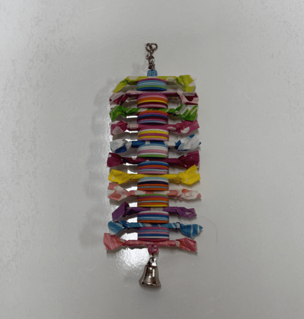 A colorful string of Candy hanging on a white surface.